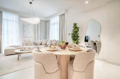 a white living room with a table and chairs at Luxury 2-Bed Apartment l Emaar Beachfront in Dubai