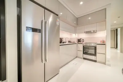 a large kitchen with a stainless steel refrigerator at Luxury 2-Bed Apartment l Emaar Beachfront in Dubai