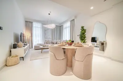 a white living room with a table and chairs at Luxury 2-Bed Apartment l Emaar Beachfront in Dubai