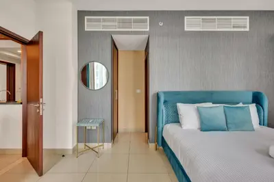 a bedroom with a blue bed and a mirror at Bellavista - 29 BLVD - 1 Bedroom Burj Khalifa & Fountain View in Dubai