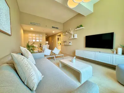 a living room with a couch and a flat screen tv at Urban Oasis Stylish JLT Apartment with Lake Views in Dubai