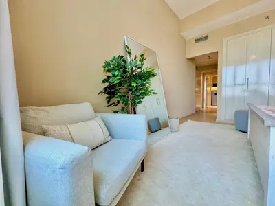 a living room with a couch and a plant at Urban Oasis Stylish JLT Apartment with Lake Views in Dubai