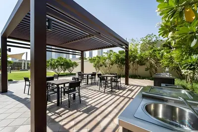 a patio with tables and chairs and a grill at Charming 1BR Apartment in Downtown Views 1, Downtown Dubai by Deluxe Holiday Homes in Dubai