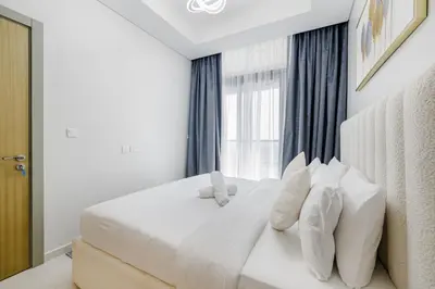 a bedroom with a white bed with pillows and a window at ALiving Charming 1BR I Aykon City Tower, Business Bay in Dubai