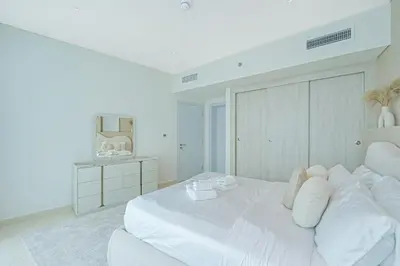 a white bedroom with a large white bed with white pillows at Beach access I Sea View I Infinity pool in Dubai