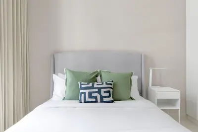 a bed with green and white pillows on it at Stunning 3 Bedroom Apartment with Fountain Views by ZEN STAYS - Sleeps 9 - 2 Balconies in Dubai