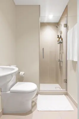 a white bathroom with a toilet and a shower at Stunning 3 Bedroom Apartment with Fountain Views by ZEN STAYS - Sleeps 9 - 2 Balconies in Dubai