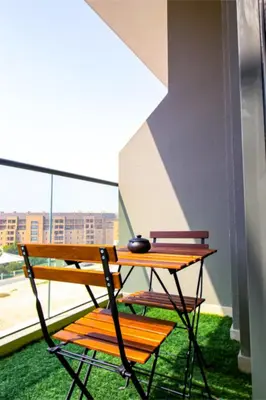 a wooden table and chair sitting on a balcony at Sky View, Furnished, FreeParking in Dubai