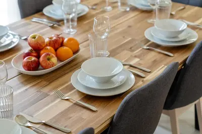 a wooden table with plates and bowls of fruit on it at Backyard Bliss Villa in The Lakes 3BR plus maid's room in Dubai
