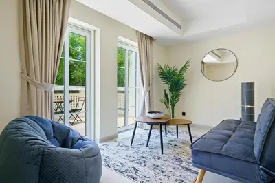 a living room with a blue couch and a table at Backyard Bliss Villa in The Lakes 3BR plus maid's room in Dubai