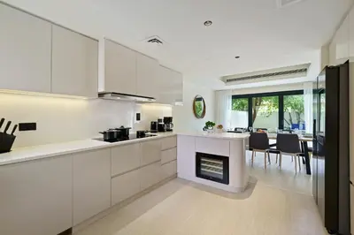 a kitchen with white cabinets and a fireplace at Backyard Bliss Villa in The Lakes 3BR plus maid's room in Dubai