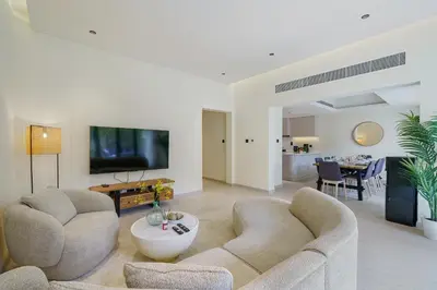 a living room with two couches and a flat screen tv at Backyard Bliss Villa in The Lakes 3BR plus maid's room in Dubai