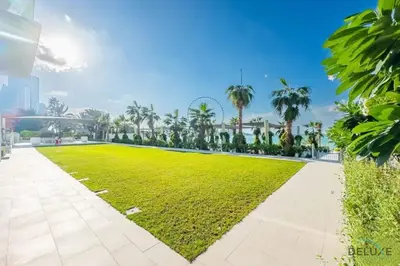a park with a green lawn and palm trees at Sophisticated 1BR Apartment in La Vie, Jumeirah Beach Residences by Deluxe Holiday Homes in Dubai