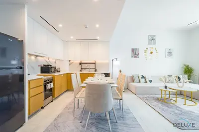 a kitchen and living room with a table and chairs at Sophisticated 1BR Apartment in La Vie, Jumeirah Beach Residences by Deluxe Holiday Homes in Dubai