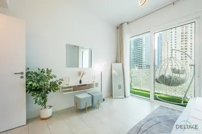 a white living room with a large window and a desk at Sophisticated 1BR Apartment in La Vie, Jumeirah Beach Residences by Deluxe Holiday Homes in Dubai