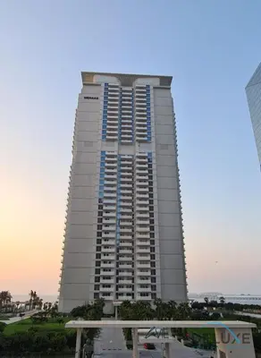 a tall white building with blue windows at Sophisticated 1BR Apartment in La Vie, Jumeirah Beach Residences by Deluxe Holiday Homes in Dubai