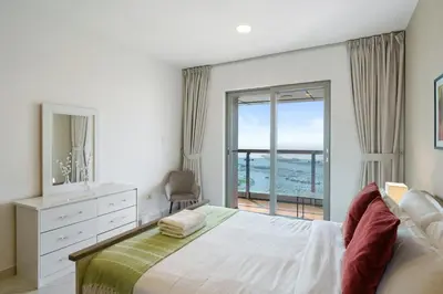 a bedroom with a large bed with a view of the ocean at Sky Haven in 45th Floor 2BR with Dubai Harbour Views in Dubai
