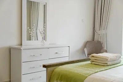 a bedroom with a dresser and a bed with a mirror at Sky Haven in 45th Floor 2BR with Dubai Harbour Views in Dubai