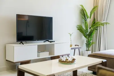 a living room with a tv on a white entertainment center at Sky Haven in 45th Floor 2BR with Dubai Harbour Views in Dubai