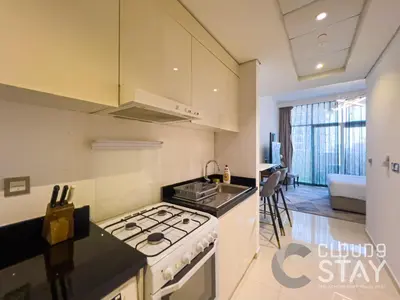 a kitchen with a stove top oven next to a sink at Cloud 9 - DAMAC Ghalia Tower in Dubai