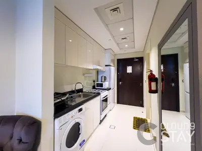 a kitchen with a washing machine and a sink at Cloud 9 - DAMAC Ghalia Tower in Dubai