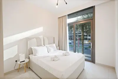a white bedroom with a bed and a window at Downtown Apartments - Burj Crown - 5 Min Walk to Mall in Dubai