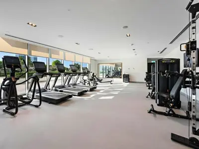 a gym with rows of treadmills and ellipticals at Sea & City Views - Burj Crown - 5 Min Walk to Mall in Dubai