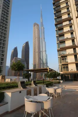 a patio with tables and chairs and buildings at Sea & City Views - Burj Crown - 5 Min Walk to Mall in Dubai