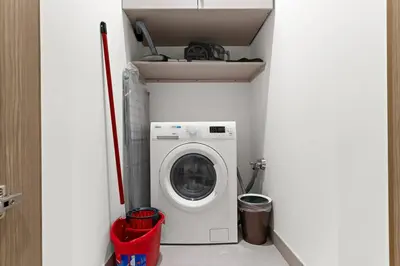 a washer and dryer in a small room at FIRST CLASS Luxury 1BR plus Bunk Room in Sobha Waves, Close to Downtown Dubai in Dubai