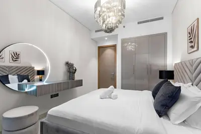 a bedroom with a large white bed and a mirror at FIRST CLASS Luxury 1BR plus Bunk Room in Sobha Waves, Close to Downtown Dubai in Dubai