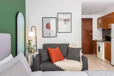 a living room with a couch and a kitchen at Silkhaus Burj Khalifa View Studio in Iconic Tower in Dubai