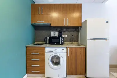 a kitchen with a washing machine and a refrigerator at Silkhaus Modern Studio with Balcony in Burj Daman in Dubai