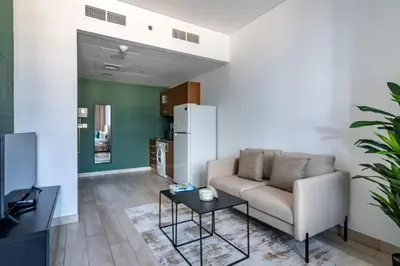 a living room with a couch and a table at Silkhaus Modern Studio with Balcony in Burj Daman in Dubai