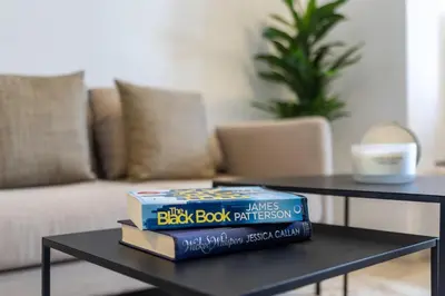 a stack of books on a table in a living room at Silkhaus Modern Studio with Balcony in Burj Daman in Dubai