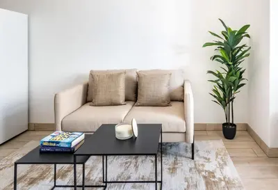 a living room with a couch and a table at Silkhaus Modern Studio with Balcony in Burj Daman in Dubai