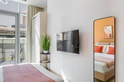 a bedroom with a bed and a tv on a wall at Silkhaus Spacious Studio in Heart of DIFC in Dubai