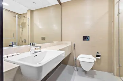 a white bathroom with a sink and a toilet at Silkhaus Stylish 1 BDR with Luxurious vibes in Dubai