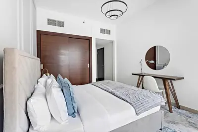 a bedroom with a bed and a table and a mirror at Silkhaus Stylish 1 BDR with Luxurious vibes in Dubai