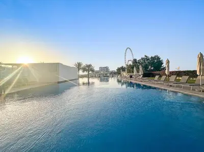 a large pool of water with a roller coaster in the background at FIRST CLASS 2BR Vibrant Waterfront District in Dubai