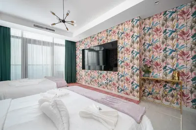 a bedroom with two beds and a tv on the wall at Sky-High Oasis with Burj Khalifa Views, Rooftop Infinity Pool, 3BR Apartment in Paramount Hotel Midtown in Dubai