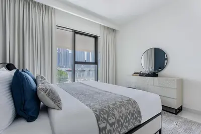 a bedroom with a bed with a mirror and a window at Frank Porter - Marina Vista Podium 3 in Dubai