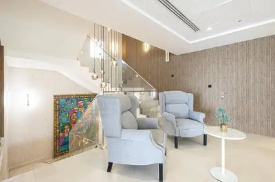 a living room with two chairs and a staircase at JuliusHomes - 5BR Villa with Pool in Palm Jumeirah in Dubai