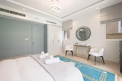 a bedroom with a large bed and two chairs at JuliusHomes - 5BR Villa with Pool in Palm Jumeirah in Dubai