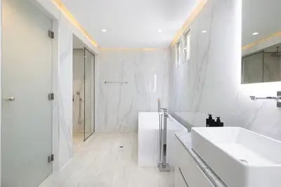 a white bathroom with a sink and a mirror at JuliusHomes - 5BR Villa with Pool in Palm Jumeirah in Dubai