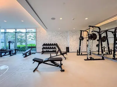 a gym with several tread machines in a room at Fully Equipped 1BR with Private Beach Access in Dubai