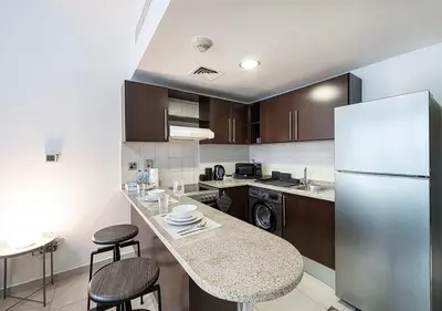 a kitchen with a counter and a refrigerator at Lux Studio in JLT with Amazing View Next to the Metro - Dubai Arch tower in Dubai