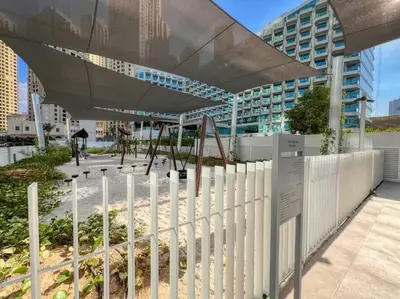 a white fence in front of a building at Panoramic Sea View 2BR in JBR in Dubai