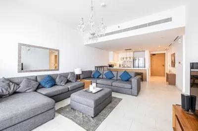 a living room with a gray couch and blue pillows at Panoramic Sea View 2BR in JBR in Dubai