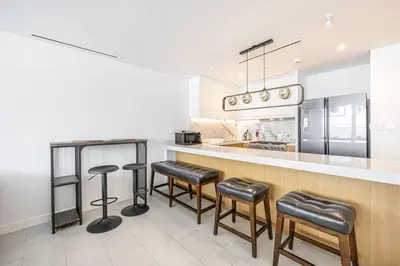 a kitchen with a bar with stools and a counter at Panoramic Sea View 2BR in JBR in Dubai