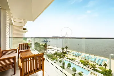 a balcony with a view of a pool and the ocean at Panoramic Sea View 2BR in JBR in Dubai